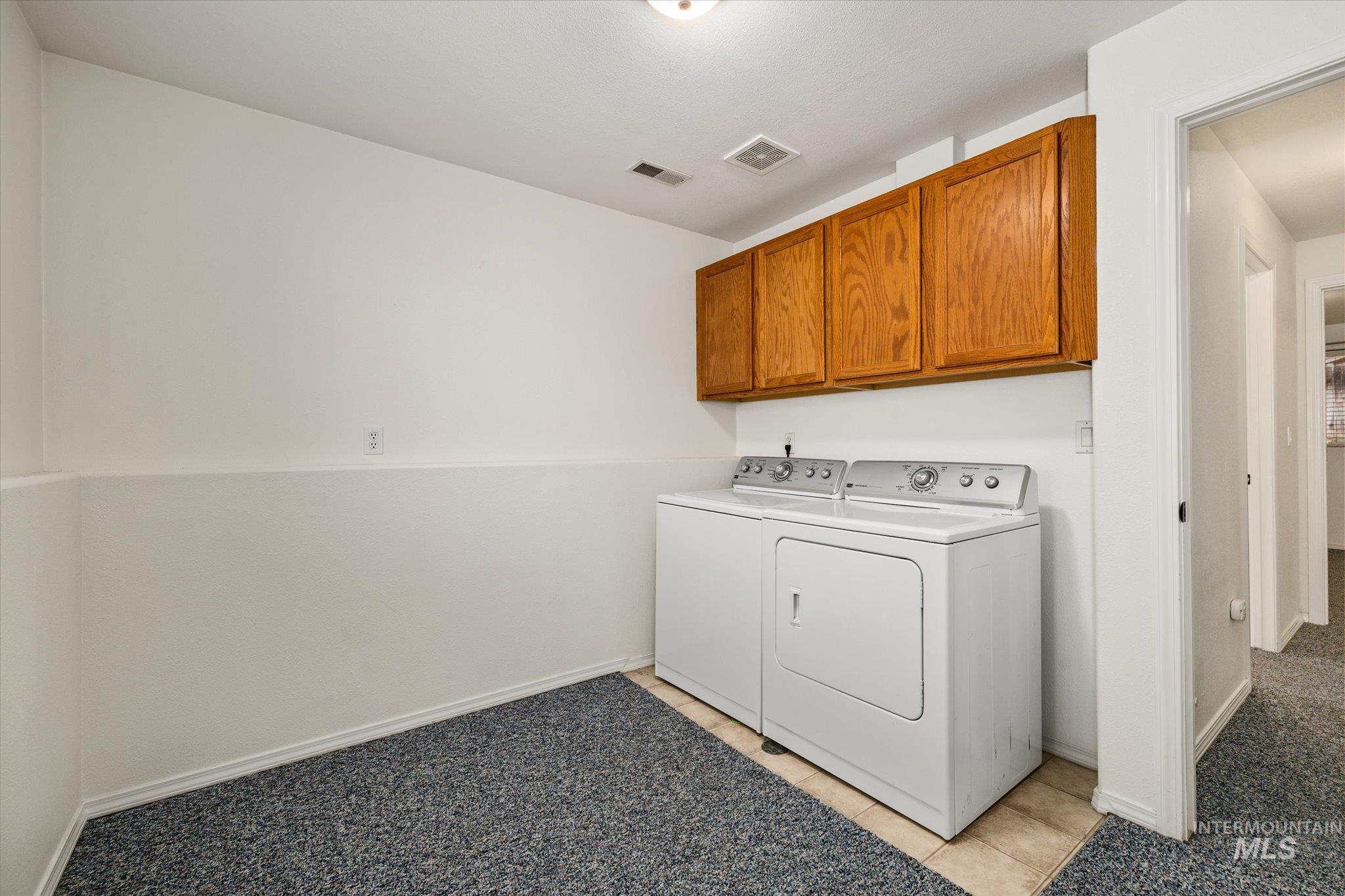2870 North Morello Avenue Meridian, ID 83646 - Photo 13 of 20 Washroom featuring washer and clothes dryer, cabinet space, and light tile patterned floors