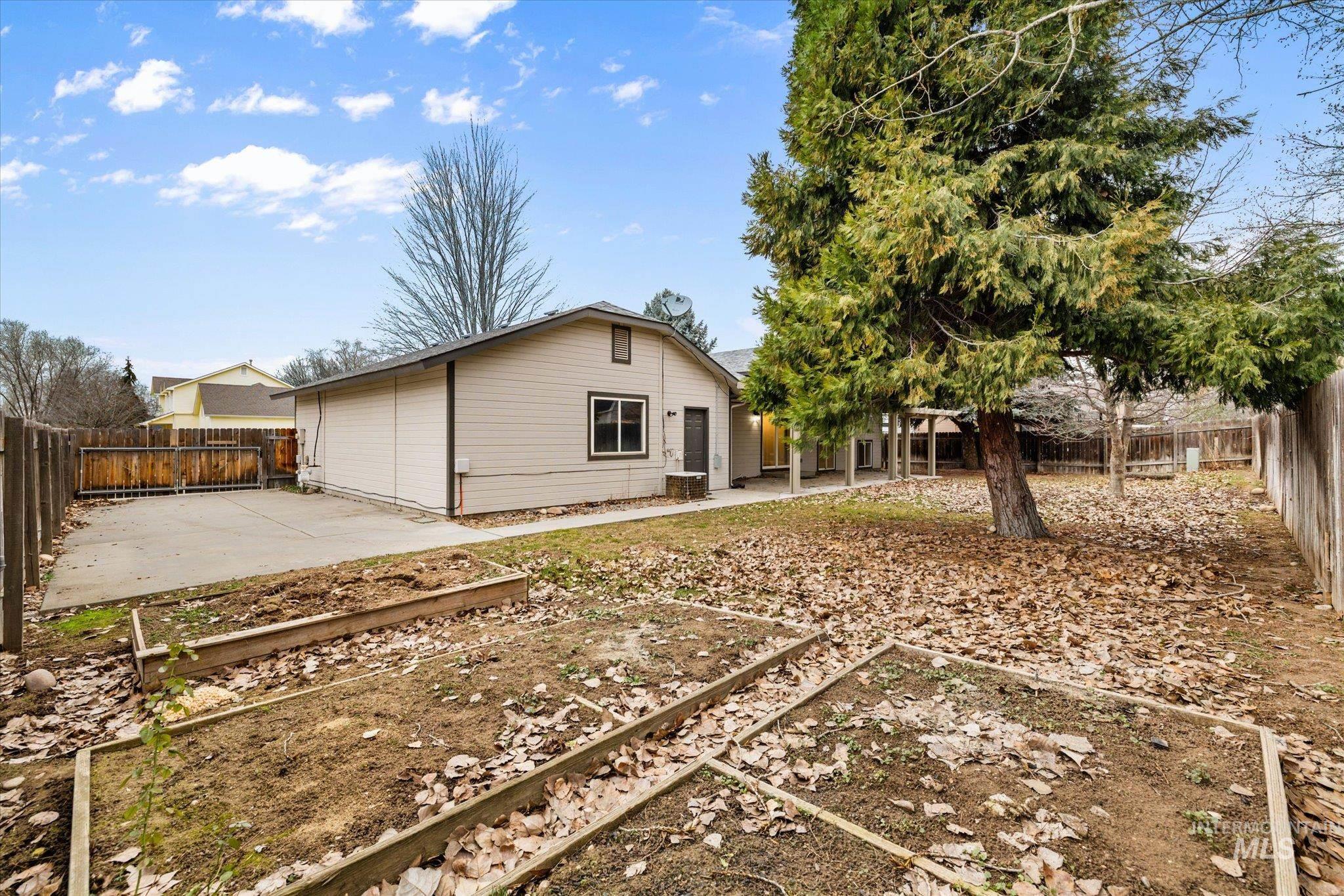 2870 North Morello Avenue Meridian, ID 83646 - Photo 17 of 20 Back of house featuring a vegetable garden, a fenced backyard, and a patio