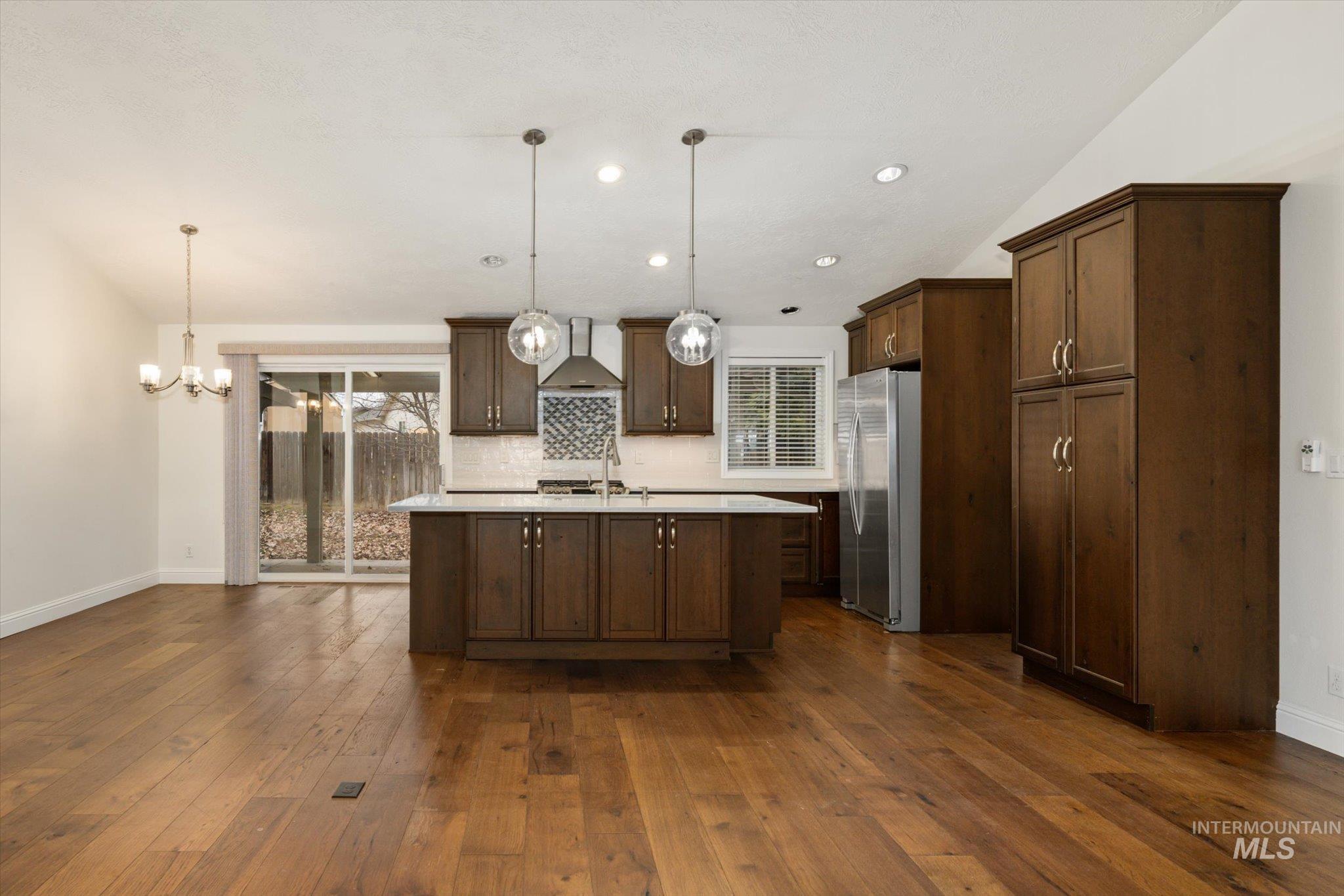 2870 North Morello Avenue Meridian, ID 83646 - Photo 20 of 20 Kitchen with hanging light fixtures, dark wood-style flooring, an island with sink, and recessed lighting
