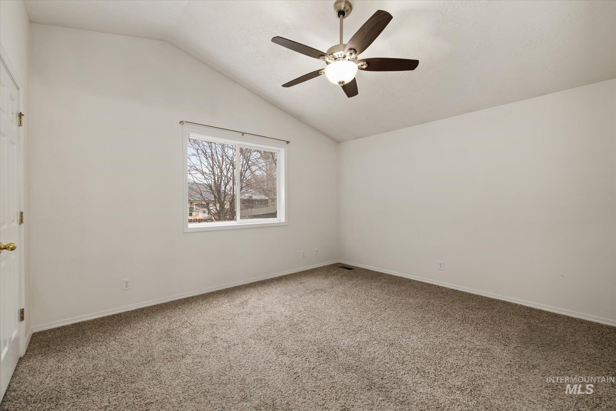 2870 North Morello Avenue Meridian, ID 83646 - Photo 4 of 20 Carpeted spare room featuring lofted ceiling and ceiling fan
