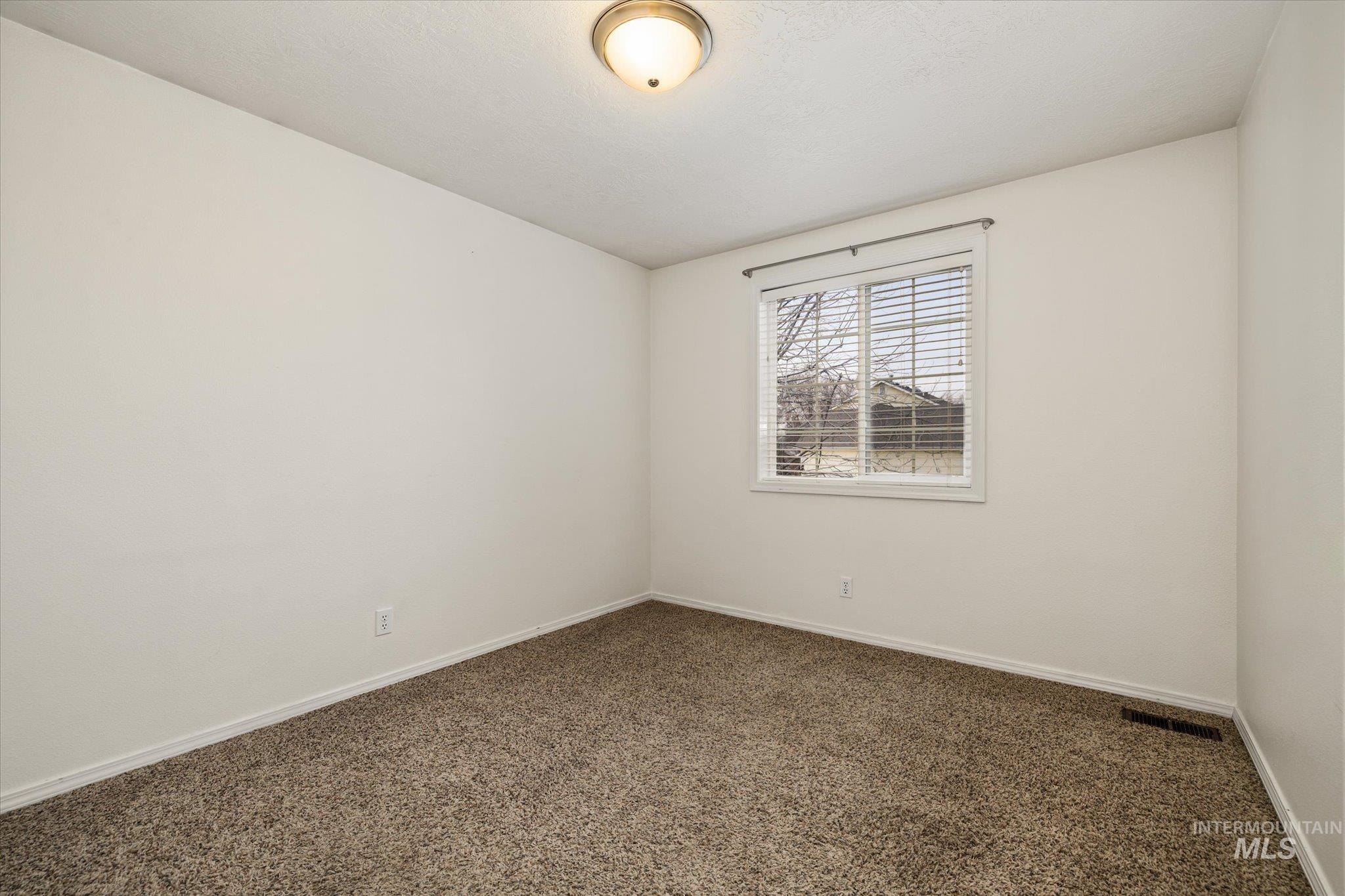 2870 North Morello Avenue Meridian, ID 83646 - Photo 8 of 20 Empty room featuring dark carpet and baseboards