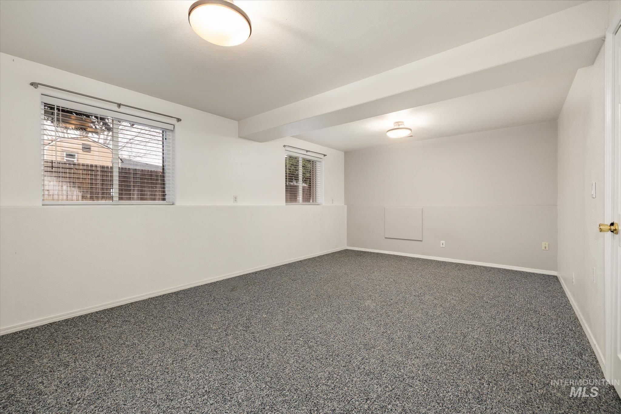 2870 North Morello Avenue Meridian, ID 83646 - Photo 10 of 20 Carpeted empty room featuring beamed ceiling and baseboards
