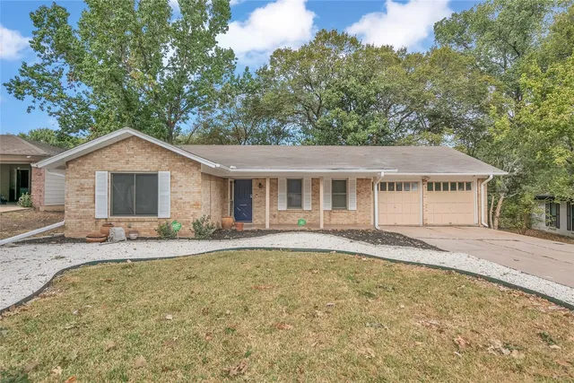a front view of house with yard and trees in the background