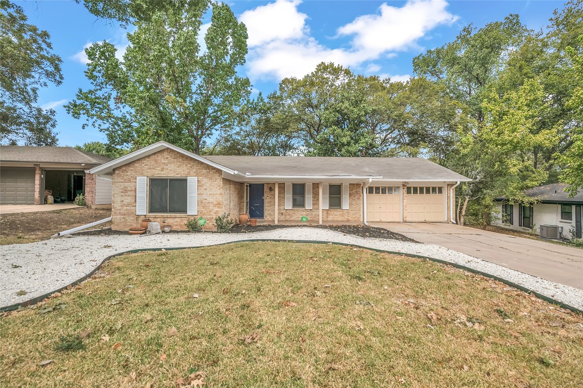 3400 Laguna Drive Austin, TX 78741 - Photo 2 of 24 Ranch-style house with concrete driveway, an attached garage, covered porch, brick siding, and a front yard