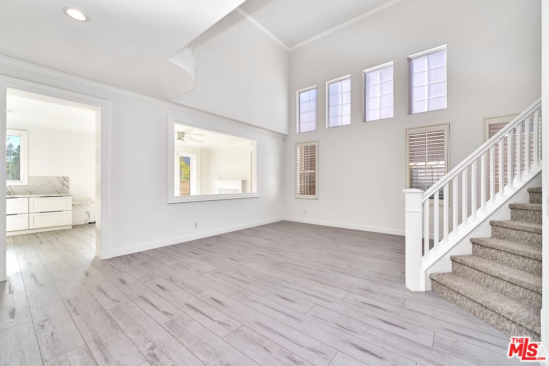25614 Lewis Way Stevenson Ranch, CA 91381 - Photo 11 of 55 a view of an empty room with wooden floor and a window