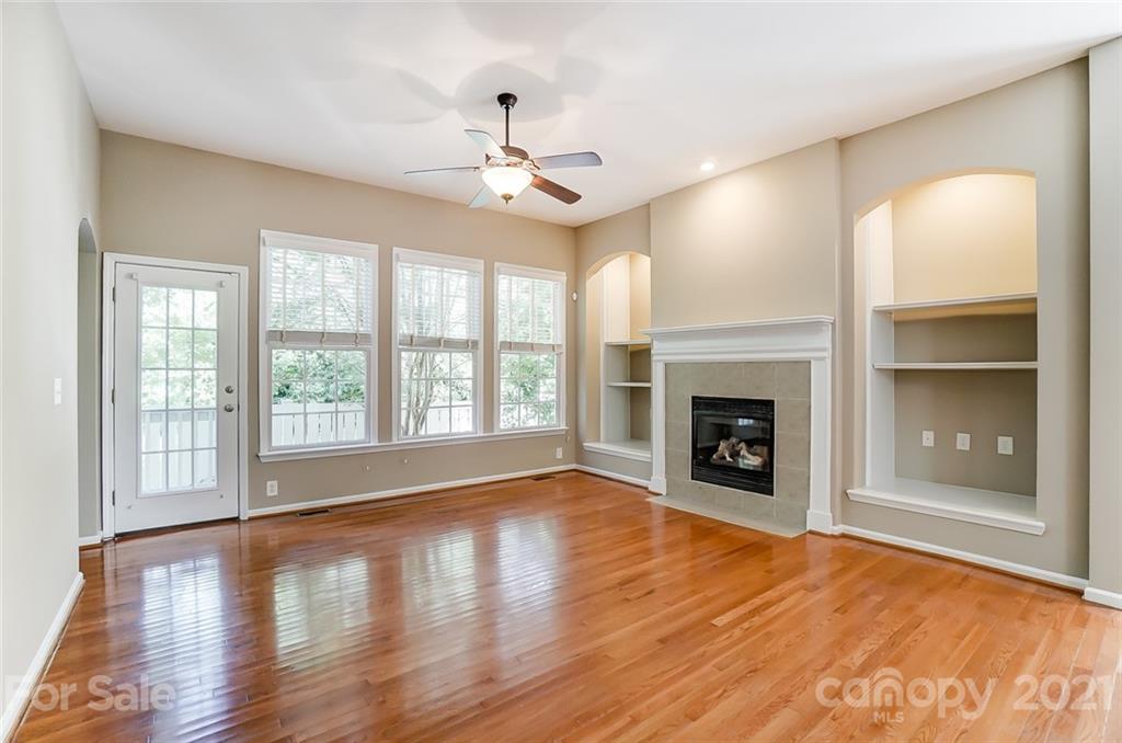 142 Blandina Court Fort Mill, SC 29708 - Photo 12 of 40 an empty room with wooden floor fireplace and windows