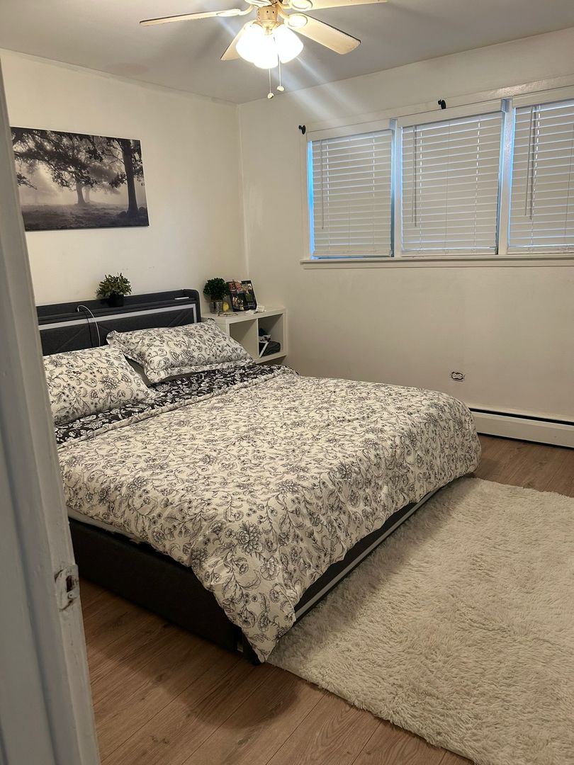 5601 West Byron Street, Unit A Chicago, IL 60634 - Photo 7 of 7 a bed sitting in a bedroom next to a window