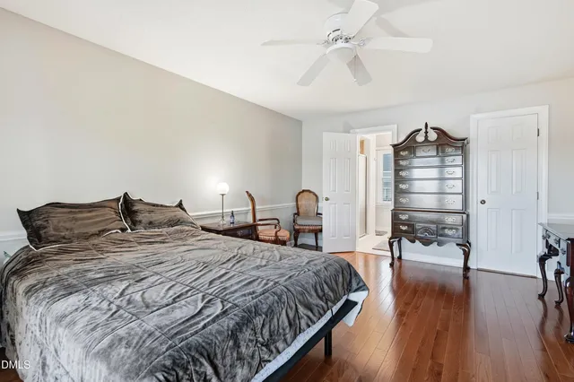 a bedroom with a bed windows and chair