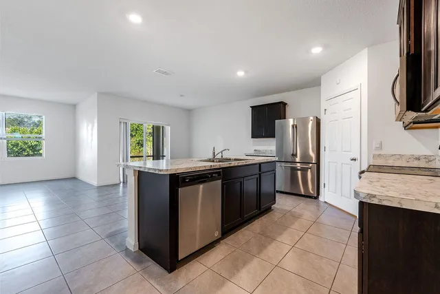 a kitchen with stainless steel appliances granite countertop a sink stove and refrigerator