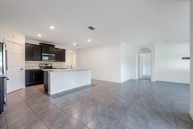 a kitchen with granite countertop stainless steel appliances and refrigerator