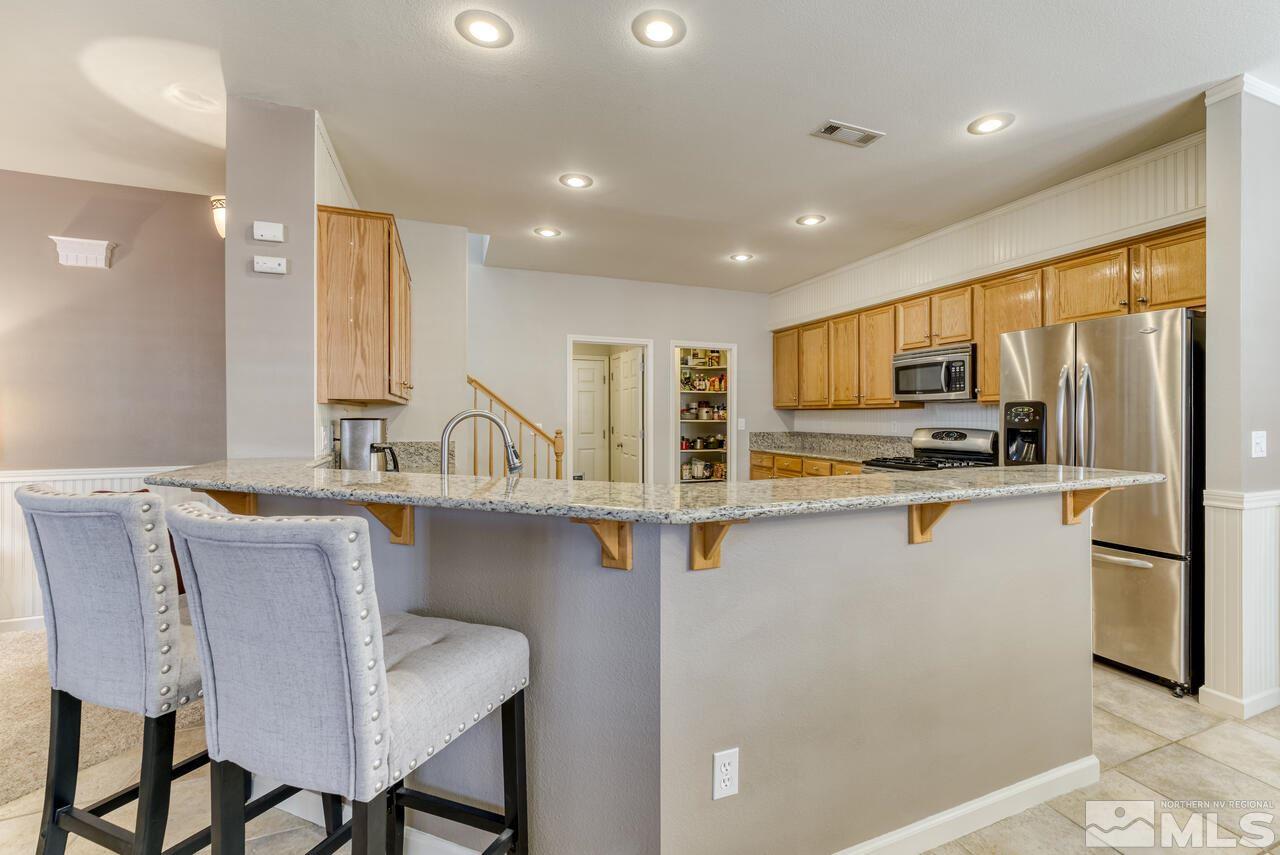 9725 Rolling Rock Court Reno, NV 89521 - Photo 10 of 39 a kitchen with counter top space cabinets and stainless steel appliances