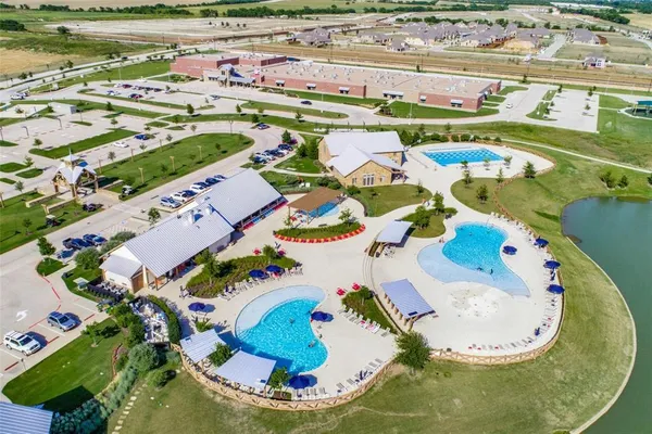 an aerial view of a swimming pool with a yard and lake