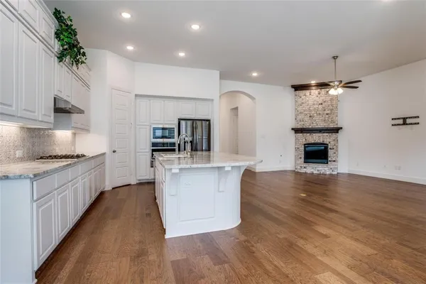 a large kitchen with cabinets wooden floor and stainless steel appliances