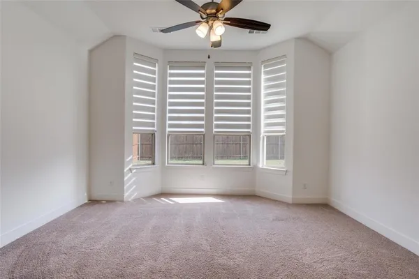 an empty room with a window and a ceiling fan
