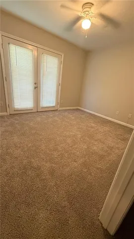 an empty room with a windows and ceiling fan