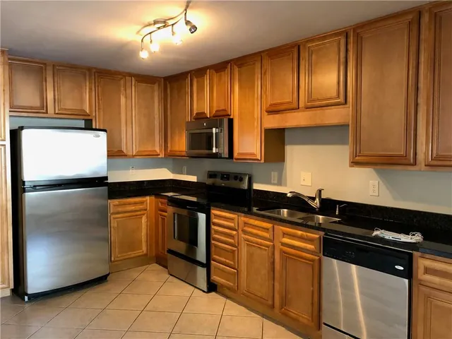 a kitchen with granite countertop stainless steel appliances and cabinets