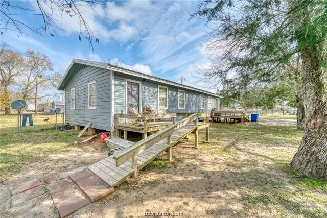 a front view of house with yard space and trees