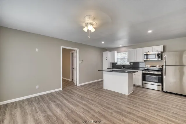 a kitchen with stainless steel appliances granite countertop a refrigerator and a stove top oven