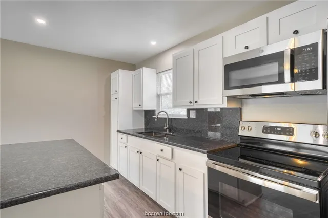 a kitchen with stainless steel appliances granite countertop a sink and a stove