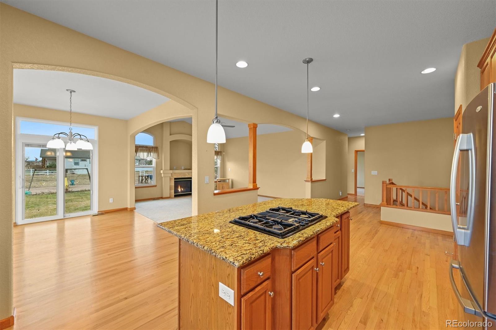 16231 Rayburn Street Hudson, CO 80642 - Photo 16 of 50 a kitchen with stainless steel appliances granite countertop a stove and white cabinets