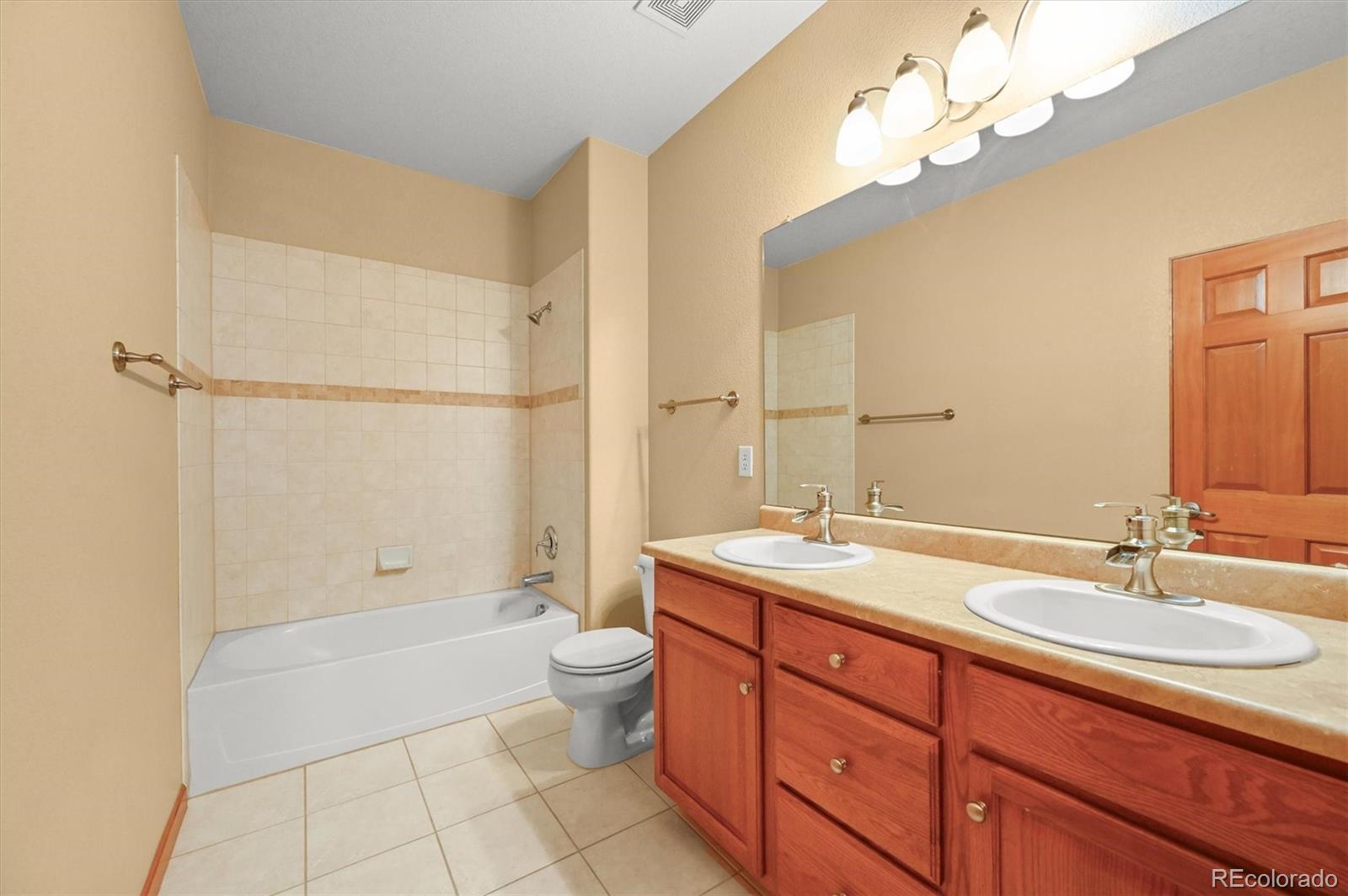 16231 Rayburn Street Hudson, CO 80642 - Photo 20 of 50 a bathroom with a granite countertop sink a toilet and bathtub
