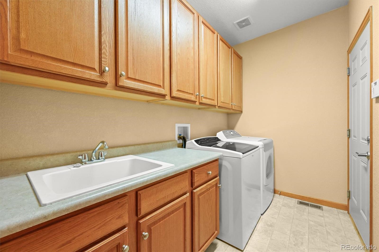 16231 Rayburn Street Hudson, CO 80642 - Photo 27 of 50 a utility room with a sink washer and dryer