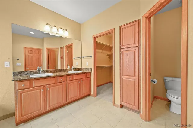a spacious bathroom with a granite countertop sink mirror and a toilet