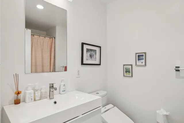 a bathroom with a toilet sink and mirror