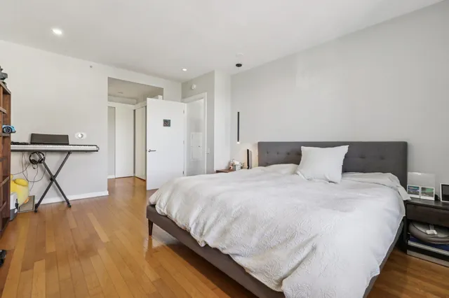 a bedroom with bed and a table with wooden floor