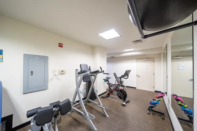 a large hall with stainless steel appliances granite countertop a sink and cabinets