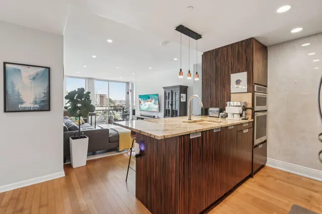 a kitchen with stainless steel appliances granite countertop a kitchen island a stove a sink a refrigerator and a refrigerator