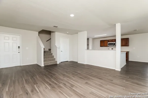 a view of an empty room with wooden floor