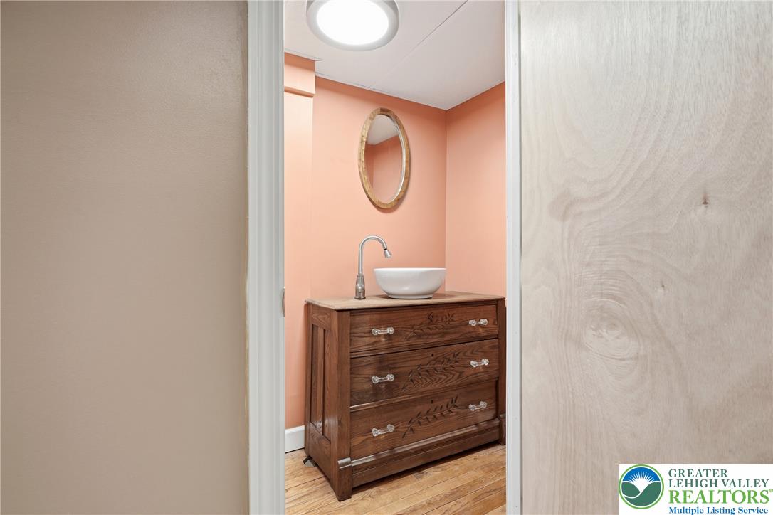 408 Maple Road Hellertown, PA 18055 - Photo 38 of 66 Rich hardwood flooring anchors this cozy half bath featuring a rustic wooden vanity cabinet.