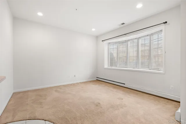 a living room with furniture a rug and kitchen view