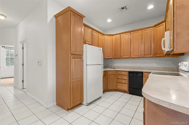 a kitchen with white cabinets and white appliances