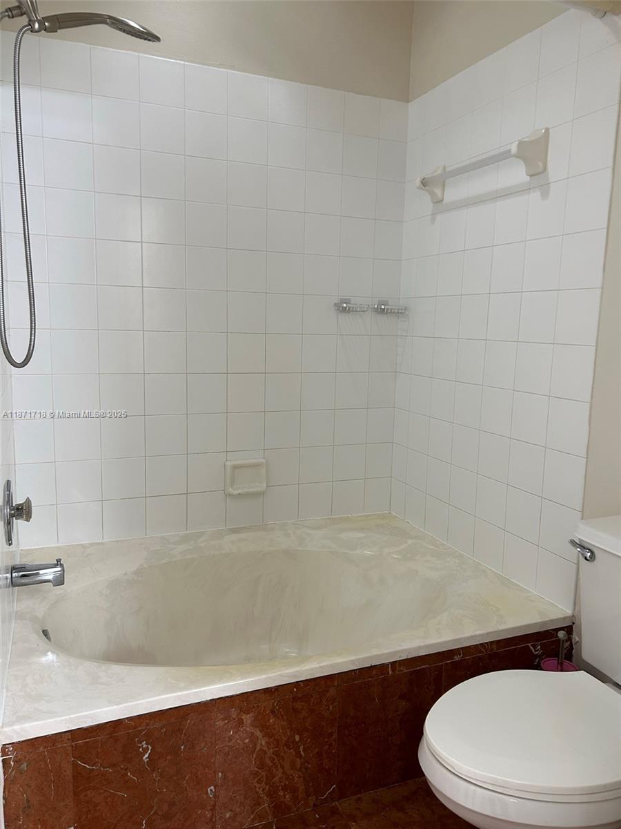 15851 Southwest 10th Street, Unit 15851 Pembroke Pines, FL 33027 - Photo 16 of 17 a white toilet sitting next to a bath tub