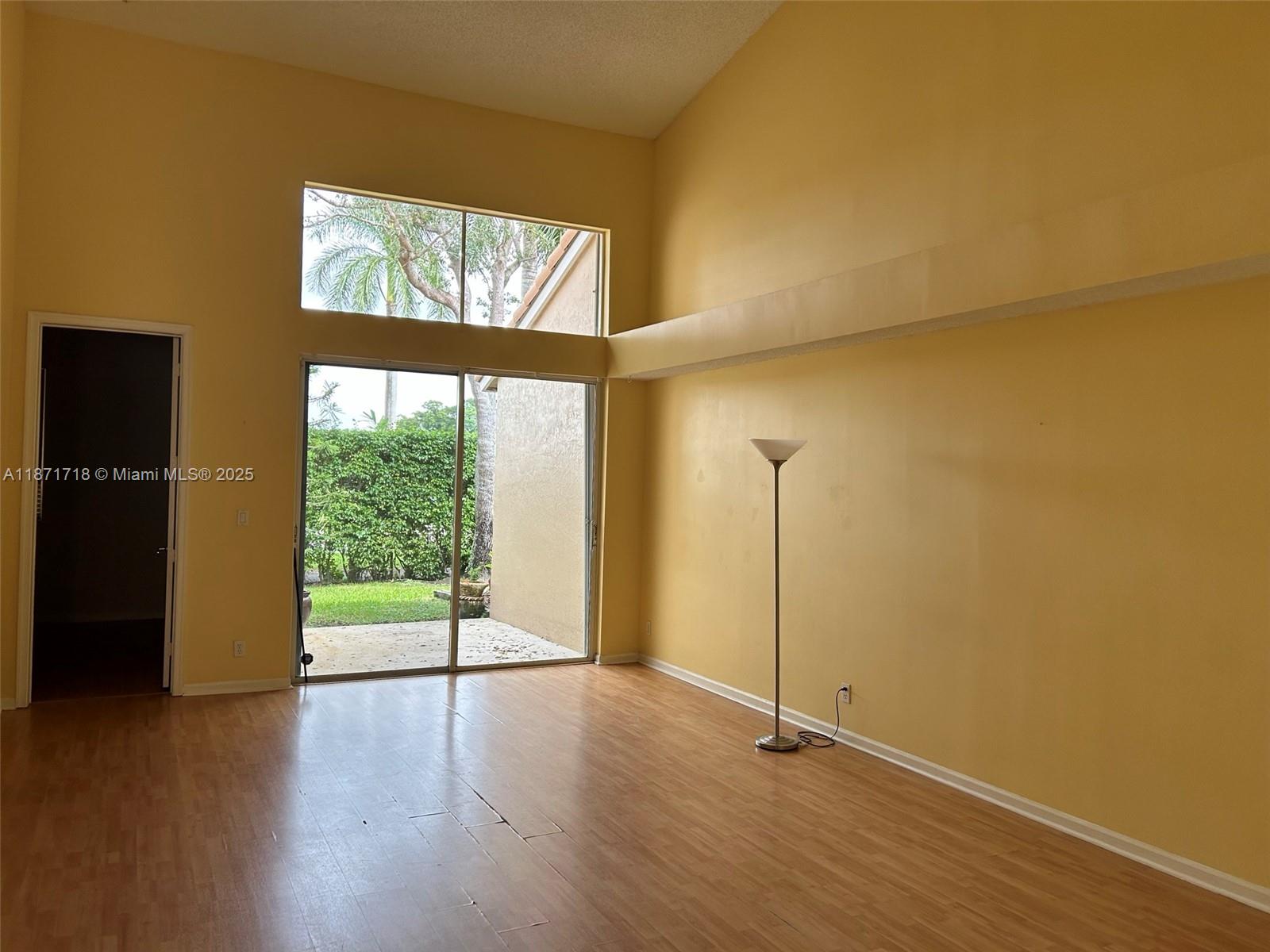 15851 Southwest 10th Street, Unit 15851 Pembroke Pines, FL 33027 - Photo 2 of 17 an empty room with wooden floor and windows