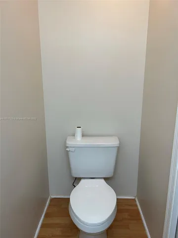 a white toilet sitting next to a white wall