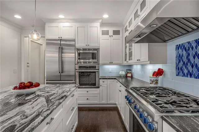 a kitchen with stainless steel appliances granite countertop a refrigerator and a sink