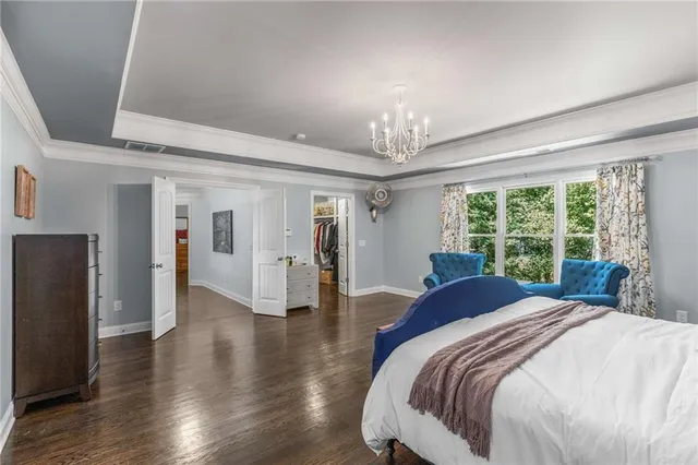 a spacious bedroom with a bed and a chandelier