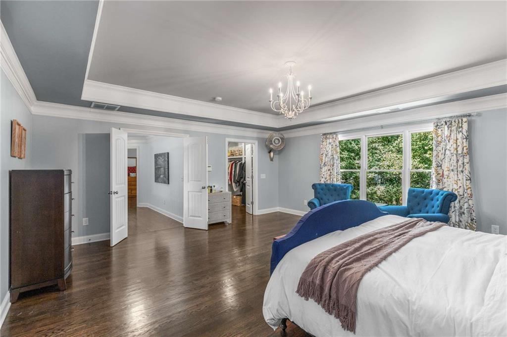 2456 Sunset Drive Northeast Atlanta, GA 30345 - Photo 24 of 49 a spacious bedroom with a bed and a chandelier