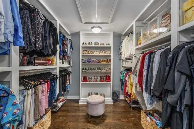 a view of walk in closet with clothes and shoes