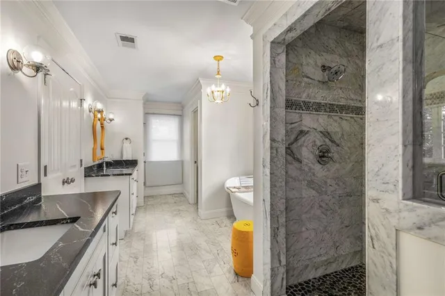 a bathroom with a granite countertop sink a toilet a mirror and shower