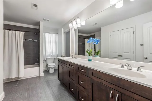 a bathroom with a double vanity sink and mirror with shower
