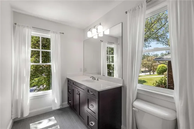 a bathroom with a granite countertop sink and a large mirror