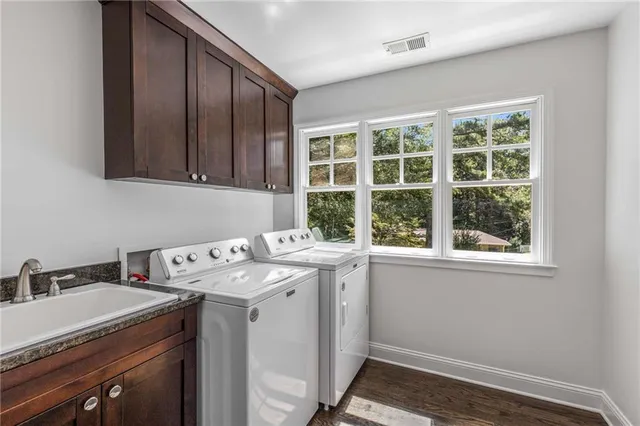 a view of a bathroom with a sink window and cabinets