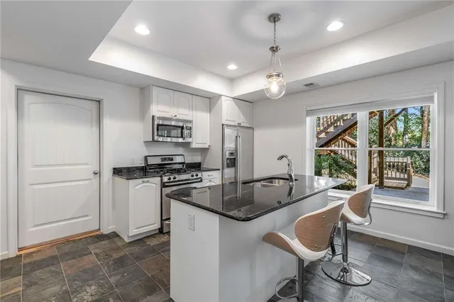 a kitchen with granite countertop a stove and refrigerator