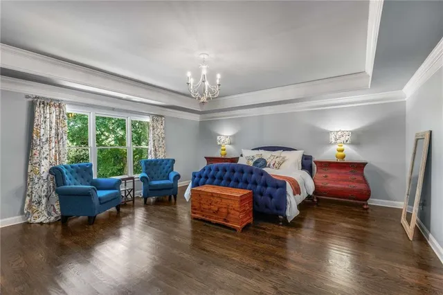 a spacious bedroom with a bed and wooden floor