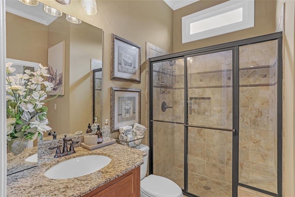 1385 Harris Road Lawrenceville, GA 30043 - Photo 12 of 76 a bathroom with a granite countertop sink toilet and shower