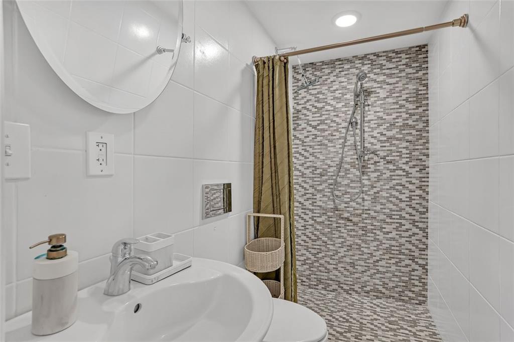 1385 Harris Road Lawrenceville, GA 30043 - Photo 60 of 76 a bathroom with a sink a toilet and shower